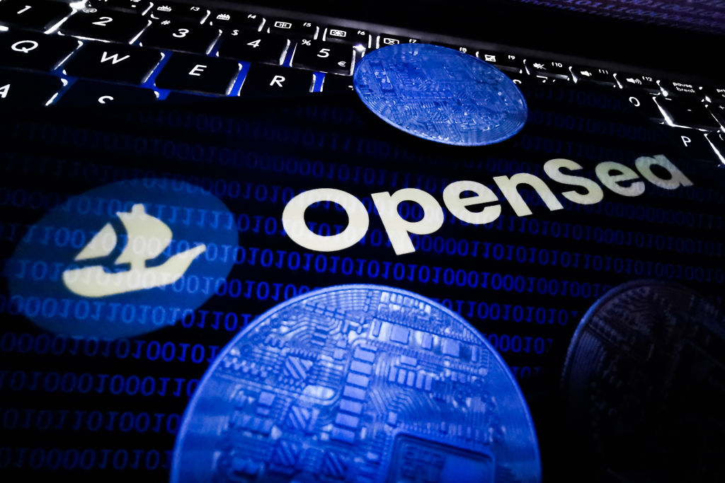 OpenSea logo displayed on a phone screen and representation of cryptocurrencies are seen in this illustration photo taken in Krakow, Poland on August 26, 2021. (Photo by Jakub Porzycki/NurPhoto via Getty Images)