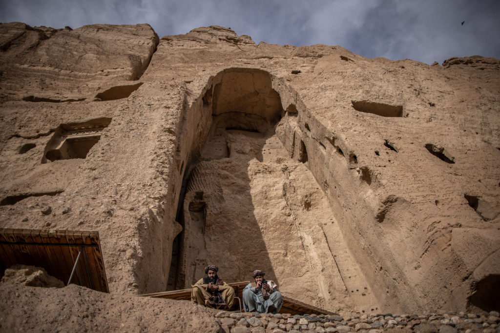 15 November 2022, Afghanistan, Bamyan: Two Taliban fighters patrol at the site where a monumental, 38 meters tall Buddha statue was carved into the side of a cliff in Bamyan. Two massive buddha statues with the smaller reaching 38 and the larger reaching 55 meters where built circa 600 CE and later destroyed by the Taliban with dynamite over several weeks, starting on 02 March 2001. Photo: Oliver Weiken/dpa (Photo by Oliver Weiken/picture alliance via Getty Images)
