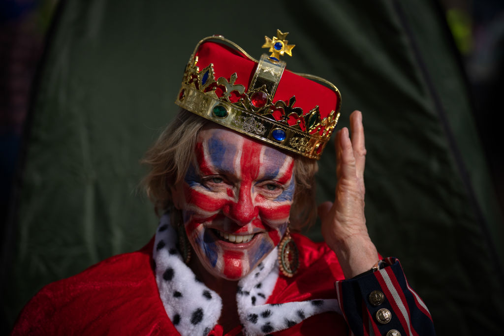 LONDON, ENGLAND - MAY 5: A royal fan adjusts her fake crown as she waits on The Mall ahead of tomorrow's royal coronation, on May 5, 2023 in London, England. The Coronation of King Charles III and The Queen Consort will take place on May 6, part of a three-day celebration. (Photo by Carl Court/Getty Images)