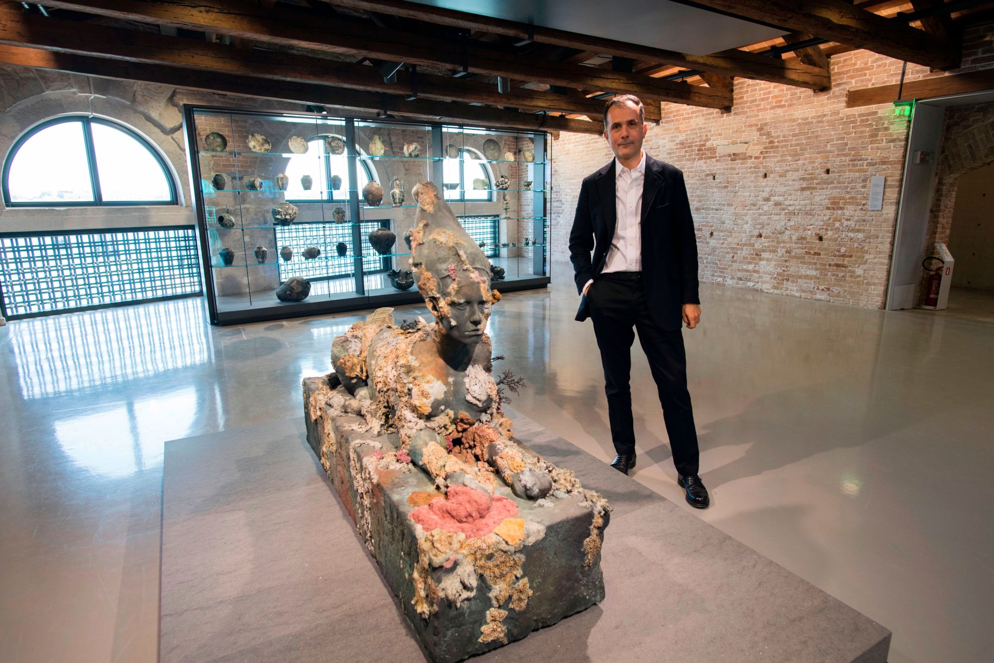 Palazzo Grassi & Punta della Dogana director, Martin Bethenod poses next to the "Sphinx" by British artist Damien Hirst during the press presentation of his exhibition "Treasures from the Wreck of the Unbelievable" at the Pinault Collection in Punta della Dogana and Palazzo Grassi in Venice on April 6, 2017. / AFP PHOTO / MIGUEL MEDINA / RESTRICTED TO EDITORIAL USE - MANDATORY MENTION OF THE ARTIST UPON PUBLICATION - TO ILLUSTRATE THE EVENT AS SPECIFIED IN THE CAPTION        (Photo credit should read MIGUEL MEDINA/AFP via Getty Images)