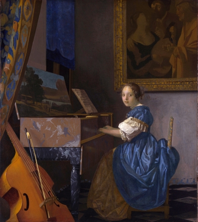 A young white woman sits at a piano-like instrument whose underside is painted with a landscape. The woman wears a dress that bunches because of her chair. She looks out at the viewer. A cello-like instrument and its bow are leaned against the piano. On a nearby wall is a partly visible painting shouting laughing partiers.